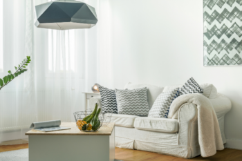 creamcolouredliving room showing sofa,coffee table and voile curtains
