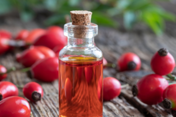 cranberry seed oil in a glass bottle and cranberries loose next to it
