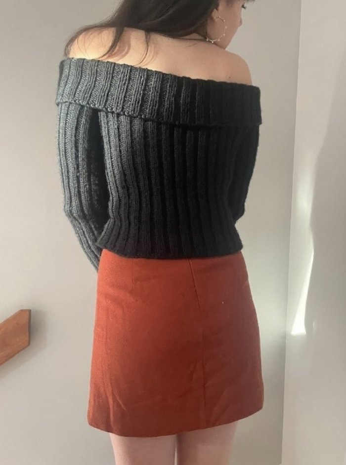 black jumper and orange skirt