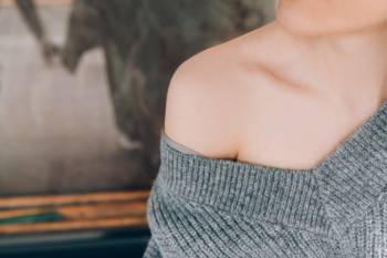 a lady wearing a grey off the shoulder jumper