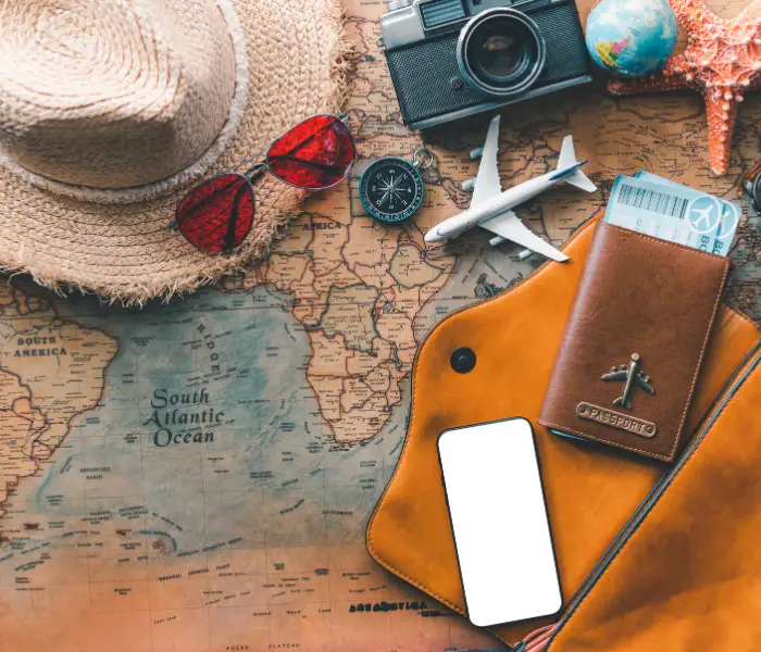 travel map, sun hat, camera, phone, toy plane, passport wallet