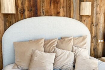 beige bed with wooden boards on wall behind