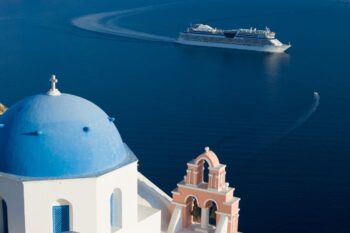 a cruise in the background in the sea. in the foreground are white buildings