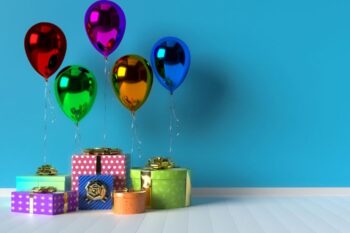 gifts and balloons in front of blue wall and on white wooden floor