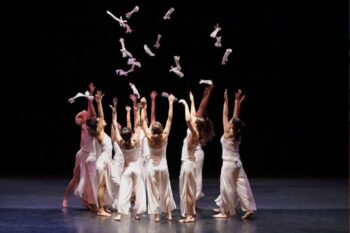 a group of dancers all dressed in white and bare foot