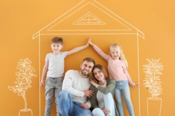 a family next to a wall with a drawn on house and trees