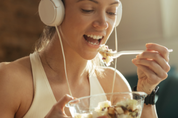 lady wearing headphones and eating pasta salad