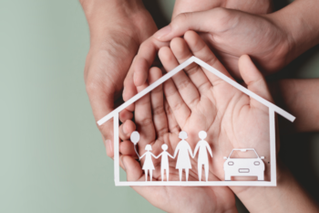 cutout family and car on pile of hands