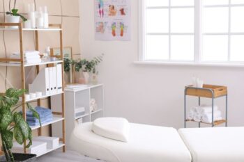 A white massage table in a room with white walls