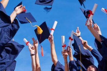 high school graduation caps being thrown into the air