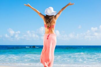 lady standing on beach with hands up