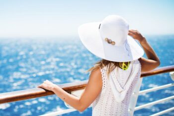 lady standing looking out to sea on a cruise wearing an all white outfit