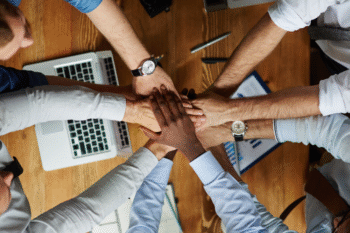 a group of people with hands together weraing business shirts