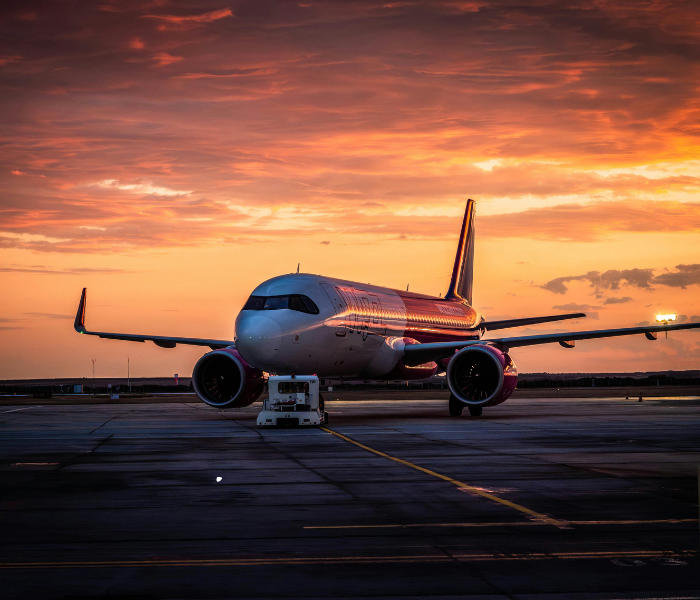 Aircraft parked on the tarmac during sunset, ready for departure before a holiday trip.