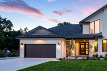 white house and garage with a grey drievaway and lawn