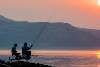 fishing with sunset behond