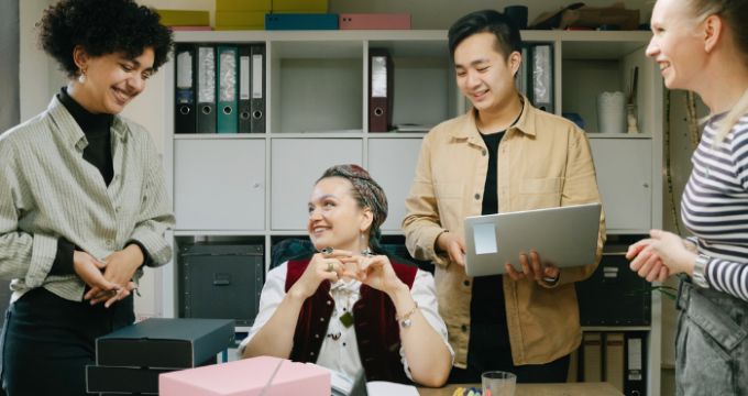 Group of diverse colleagues enjoying a casual chat and brainstorming session in a modern office environment, promoting teamwork and creativity.
