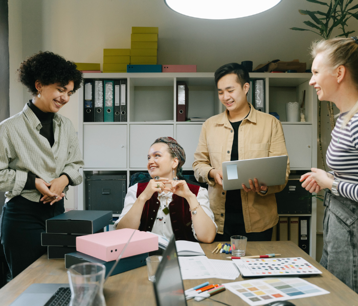Group of diverse colleagues enjoying a casual chat and brainstorming session in a modern office environment, promoting teamwork and creativity.