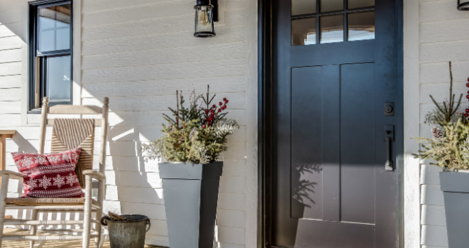 front porch with black door and rockinh chair to the side, nice planters