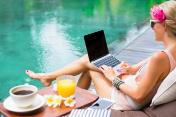 on laptop by the pool