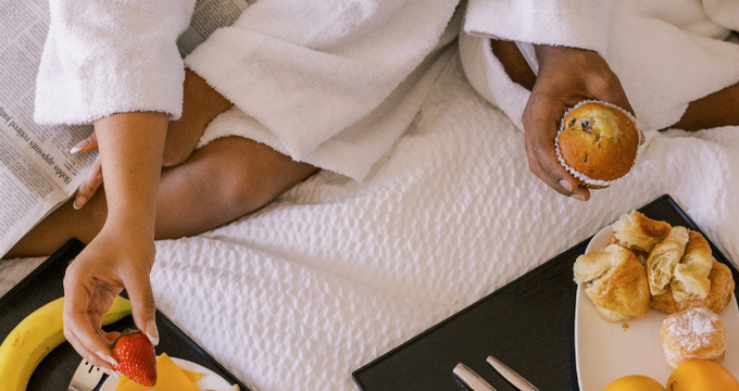 a couple eating breakfast in bed